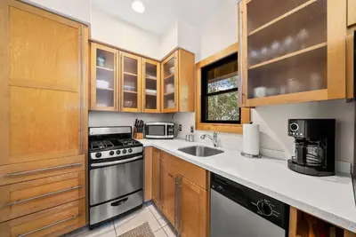 a kitchen with wooden cabinets and a stove top oven at Brighton Carriage House in Rosemary Beach