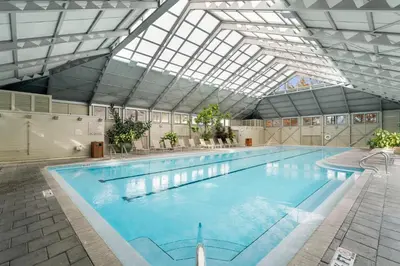 a large indoor swimming pool with a glass ceiling at Brighton Carriage House in Rosemary Beach
