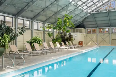 a large swimming pool with chairs and a table at Brighton Carriage House in Rosemary Beach