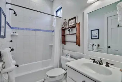 a white bathroom with a sink and a toilet at Sylvia's Cottage in Rosemary Beach