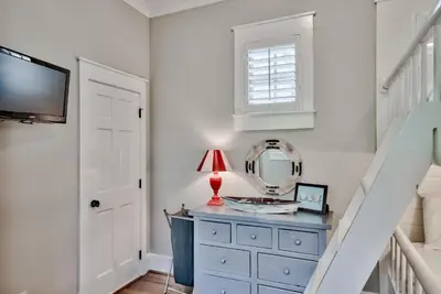 a room with a blue dresser and a mirror at Sylvia's Cottage in Rosemary Beach