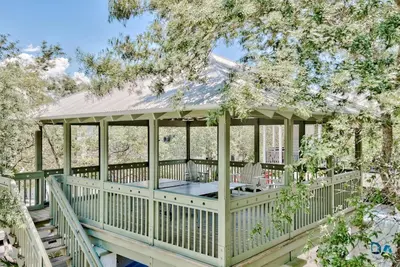 a gazebo with a table and chairs on a deck at Sylvia's Cottage in Rosemary Beach