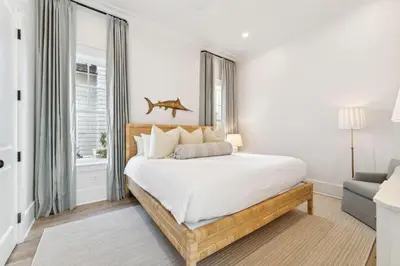 a bedroom with a bed with a fish on the wall at Beach Bear Cottage in Watersound Beach