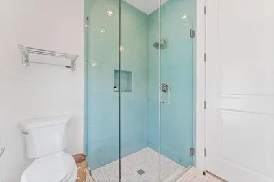 a bathroom with a toilet and a glass shower at Beach Bear Cottage in Watersound Beach