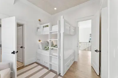 a bedroom with white walls and a white bunk bed at Beach Bear Cottage in Watersound Beach