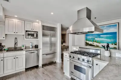 a kitchen with white cabinets and a stove top oven at Savannah 1E in Rosemary Beach