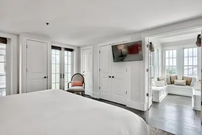 a white bedroom with a bed and a tv at Savannah 1E in Rosemary Beach