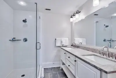 a white bathroom with two sinks and a shower at Savannah 1E in Rosemary Beach