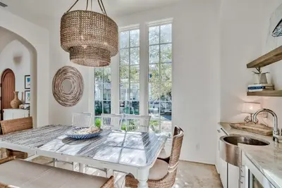 a white dining room with a table and chairs at Harper Cottage & Carriage House in Rosemary Beach