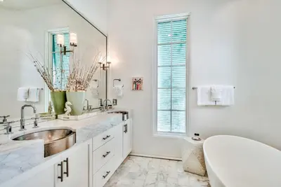 a white bathroom with a sink and a mirror at Harper Cottage & Carriage House in Rosemary Beach