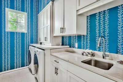 a kitchen with blue walls and a sink at Harper Cottage & Carriage House in Rosemary Beach