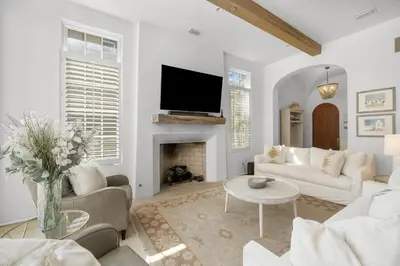 a living room with white furniture and a fireplace at Harper Cottage & Carriage House in Rosemary Beach