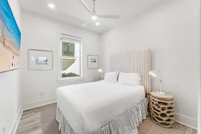 a white bedroom with a bed and a window at Wilder Dreams in Seacrest