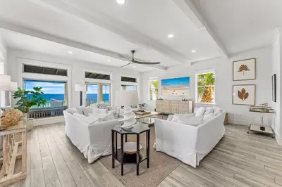 a living room with white furniture and a view of the ocean at Wilder Dreams in Seacrest