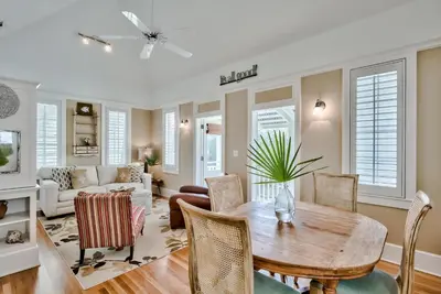 a living room with a table and chairs at Lola's Carriage House in Rosemary Beach
