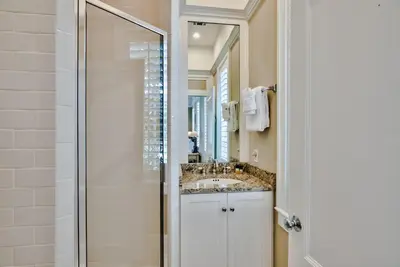 a bathroom with a sink and a mirror at Lola's Carriage House in Rosemary Beach
