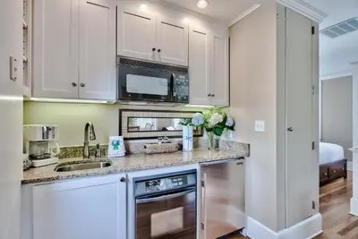 a kitchen with white cabinets and a sink at Lola's Carriage House in Rosemary Beach