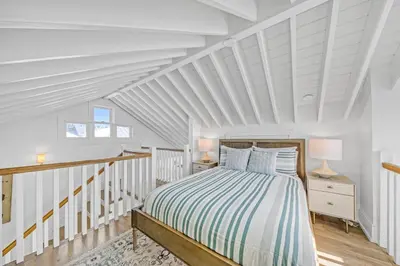 a bedroom with a bed and a white ceiling at Deauville Carriage House in Rosemary Beach