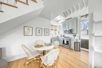 a kitchen and dining room with a table and chairs at Deauville Carriage House in Rosemary Beach