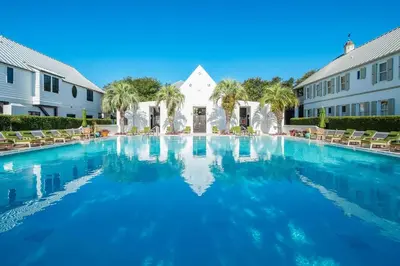 a large swimming pool in front of a building at Deauville Carriage House in Rosemary Beach