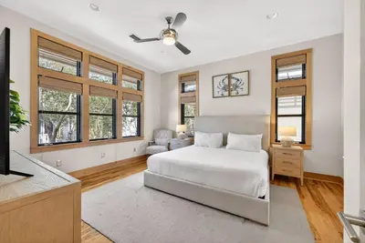 a bedroom with a bed and a tv and windows at Brighton Cottage in Rosemary Beach
