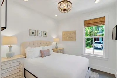 a white bedroom with a bed and a window at Flip Flop Dreams in Seacrest