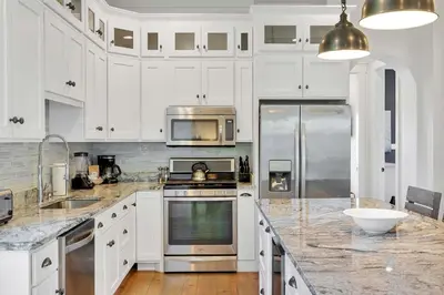 a kitchen with white cabinets and stainless steel appliances at Flip Flop Dreams in Seacrest