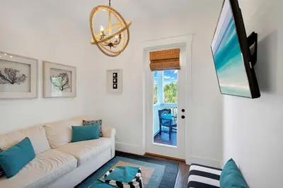 a living room with a white couch and a tv at Flip Flop Dreams in Seacrest