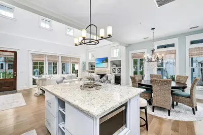 a kitchen and living room with a table and chairs at Butterfly Cottage in Rosemary Beach