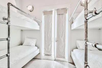 two bunk beds in a white room with a window at Clare's Cottage in Seacrest