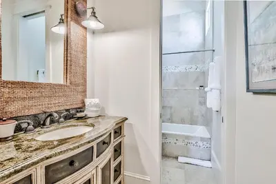 a bathroom with a sink and a mirror and a shower at Clare's Cottage in Seacrest