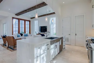 a kitchen with a sink and a living room at Kidd Cottage in Rosemary Beach