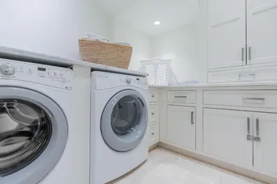 a white laundry room with a washer and dryer at Kidd Cottage in Rosemary Beach