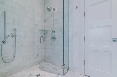 a bathroom with a shower with a glass door at Kidd Cottage in Rosemary Beach