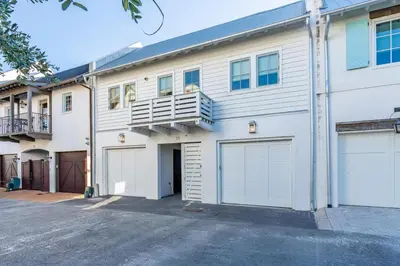 a large white building with two garage doors at Kidd Cottage in Rosemary Beach