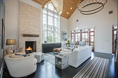 a living room with white furniture and a fireplace at Benoit Cottage in Rosemary Beach