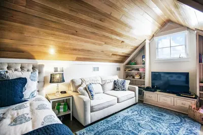 a living room with a couch and a tv at Benoit Cottage in Rosemary Beach