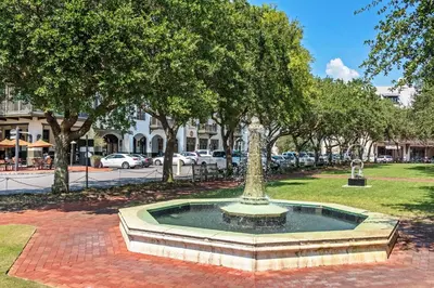 a fountain in the middle of a park with trees at Benoit Cottage in Rosemary Beach
