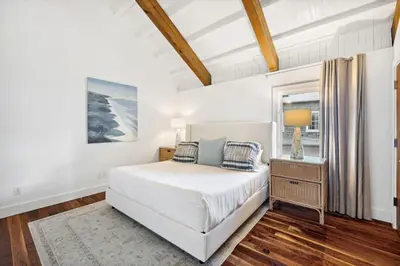 a white bedroom with a bed and a window at Kingston Beach Club in Rosemary Beach