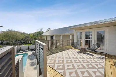 a deck with chairs and a swimming pool at Kingston Beach Club in Rosemary Beach
