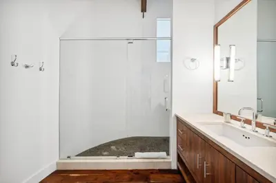 a bathroom with a glass shower and a sink at Kingston Beach Club in Rosemary Beach