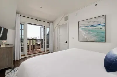 a white bedroom with a bed and a balcony at Blue Oak in Rosemary Beach