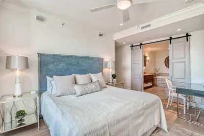 a bedroom with a large bed with a blue headboard at The Georgetown 403 in Rosemary Beach