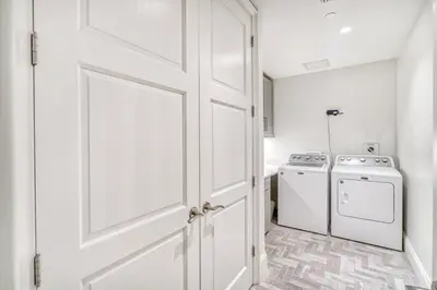 a white door in a kitchen with a washer and dryer at The Georgetown 403 in Rosemary Beach