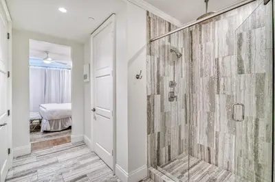 a bathroom with a shower with a glass door at The Georgetown 403 in Rosemary Beach