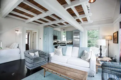 a living room with a white couch and a table at Benoit Carriage House in Rosemary Beach