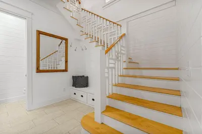 a staircase in a home with white walls and a mirror at Hope Town Pearl Cottage in Rosemary Beach