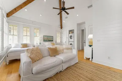 a white living room with a couch and a bed at Hope Town Pearl Cottage in Rosemary Beach