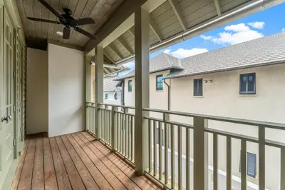a large balcony with a ceiling fan and a deck at Hope Town Pearl Cottage in Rosemary Beach