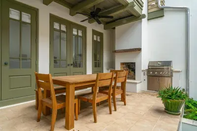 a dining room with a table and chairs and a fireplace at Hope Town Pearl Cottage in Rosemary Beach